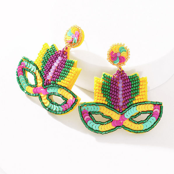mardi gras earrings propped on white white background