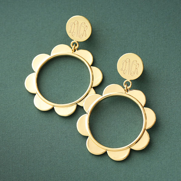 gold scallop earrings on green paper