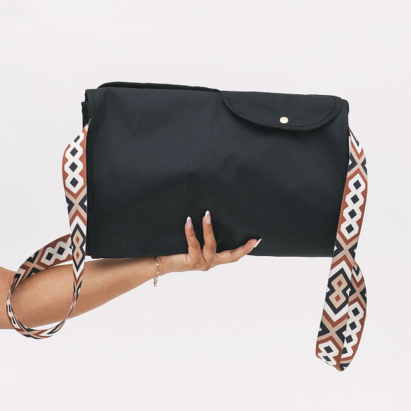 folded monogrammed storage bag in black in hands