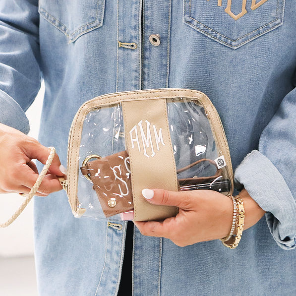 gold monogrammed clear wristlet in hands