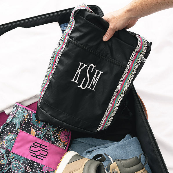 packable black spottie monogrammed weekender duffle in suitcase