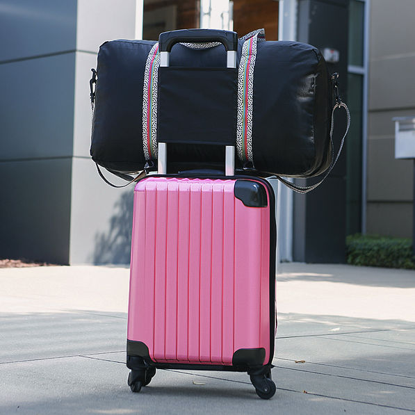 packable monogrammed black spottie duffle on pink luggage