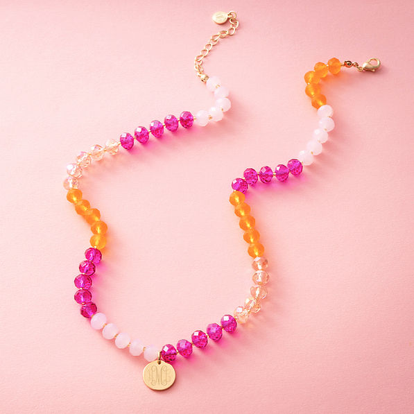 pink beaded necklace on pink background