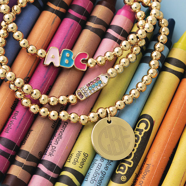 Gold monogrammed beaded teacher bracelets stack with crayons