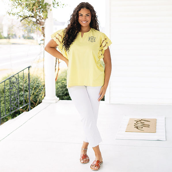 girl wearing monogrammed flutter sleeve top in soft yellow with white pants