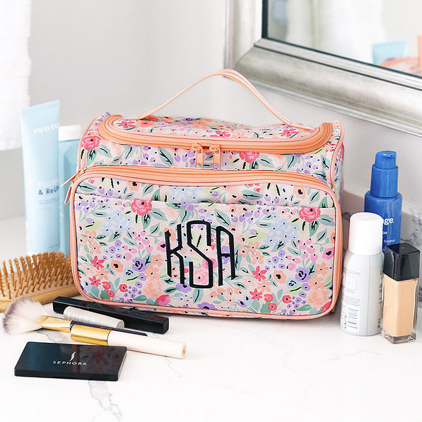 carry all monogrammed toiletry case in coral floral on bathroom counter