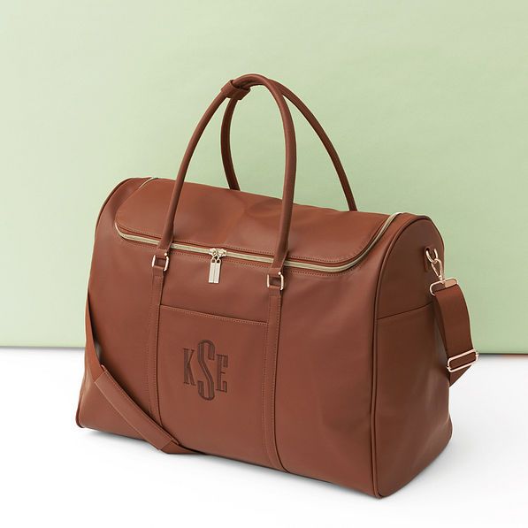 brown weekend travel bag on green background