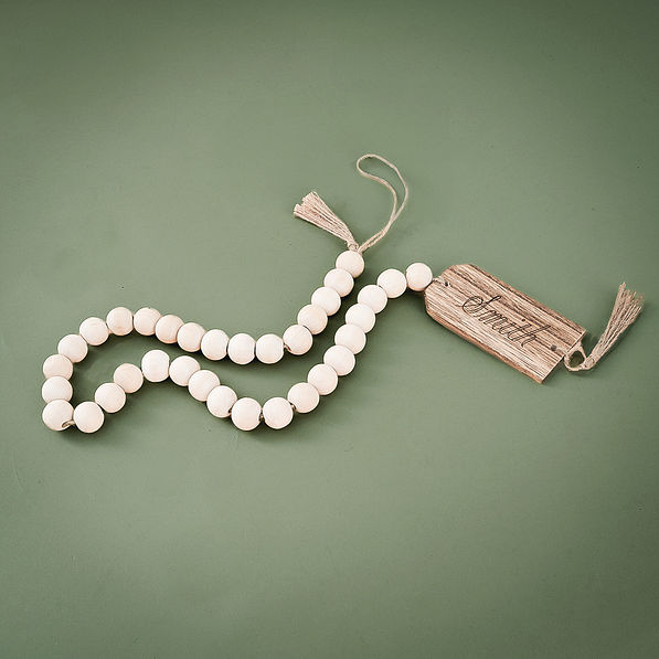 monogrammed wood bead garland on green background