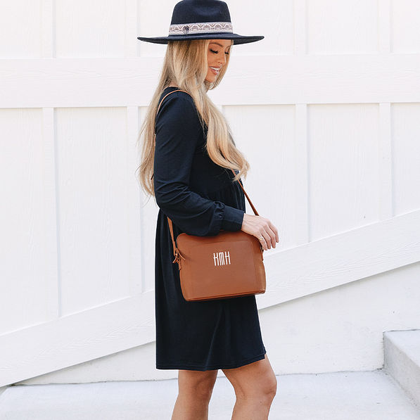 girl with brown monogrammed crossbody bag over shoulder