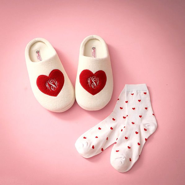 heart socks with monogrammed slippers on pink paper