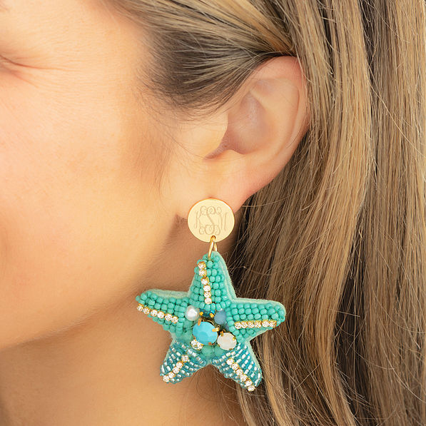 blue starfish earrings in ear