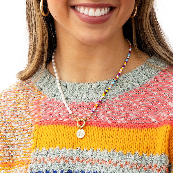 pearl bead seed necklace around neck in sweater