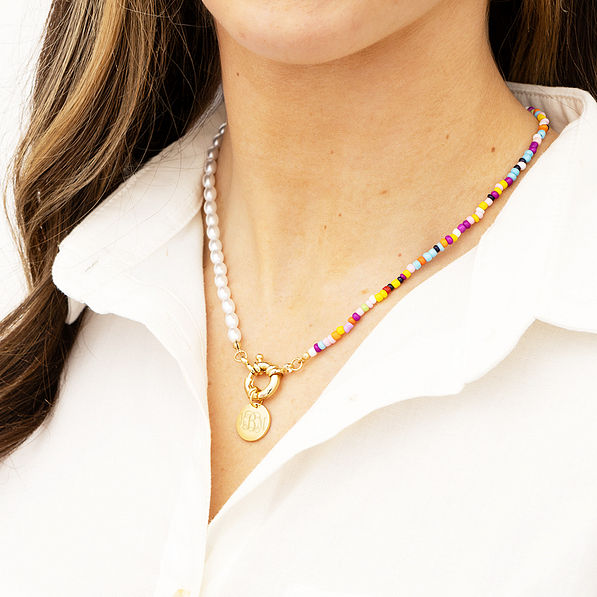 pearl seed bead necklace around neck in white collar shirt