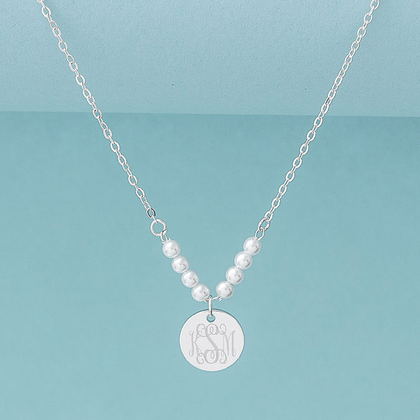 silver pearl monogrammed necklace on blue background