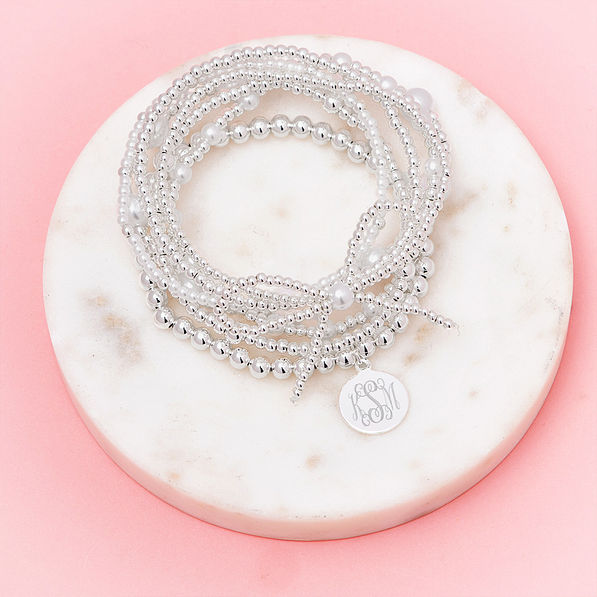 silver pearl bow bracelet stack in marble dish