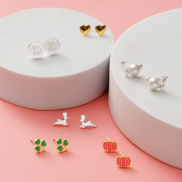 monogrammed year round earring set on white discs and pink paper