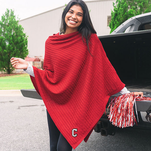 college of charleston fan wearing crimson poncho leaning on truck