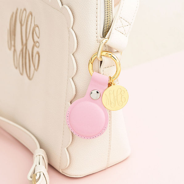pink and gold airtag key chain on crossbody bag