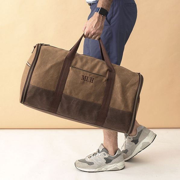 waxed canvas convertible weekend bag in hands