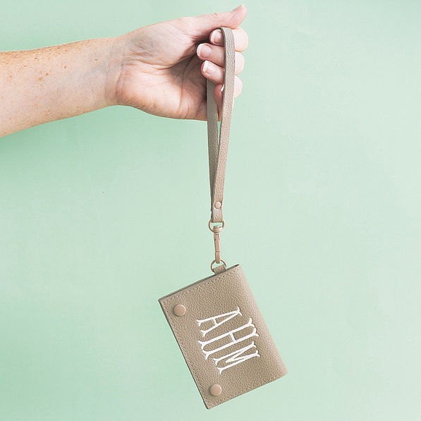 girl holding taupe monogrammed card holder wristlet