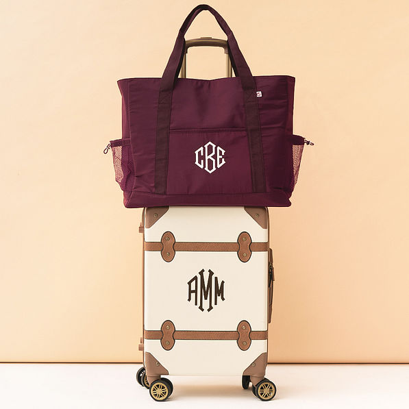 monogrammed carry on tote in burgundy on suitcase luggage