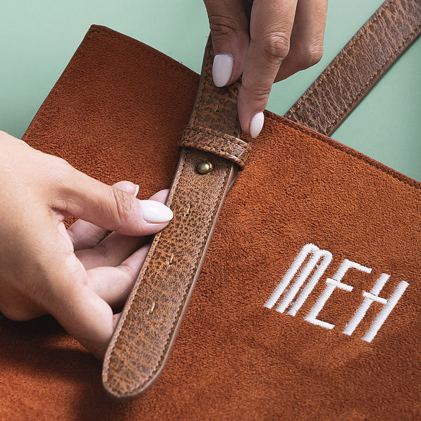 close up of suede purse adjustable strap