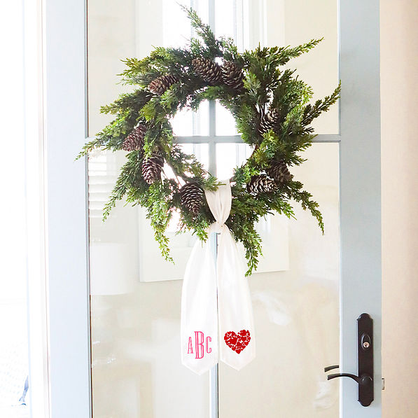 wreath on door with monogram and hearts on a wreath sash