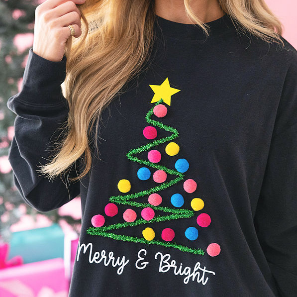 close up of black merry and bright pom pom sweatshirt