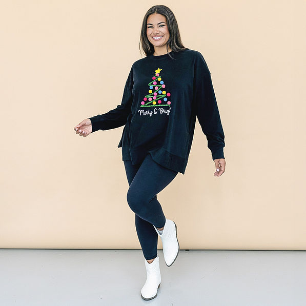 girl wearing merry and bright black christmas tree sweatshirt with leggings