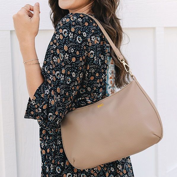girl with foil monogrammed shoulder bag in taupe over shoulder