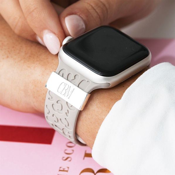 light gray smart watch band on wrist with pink background