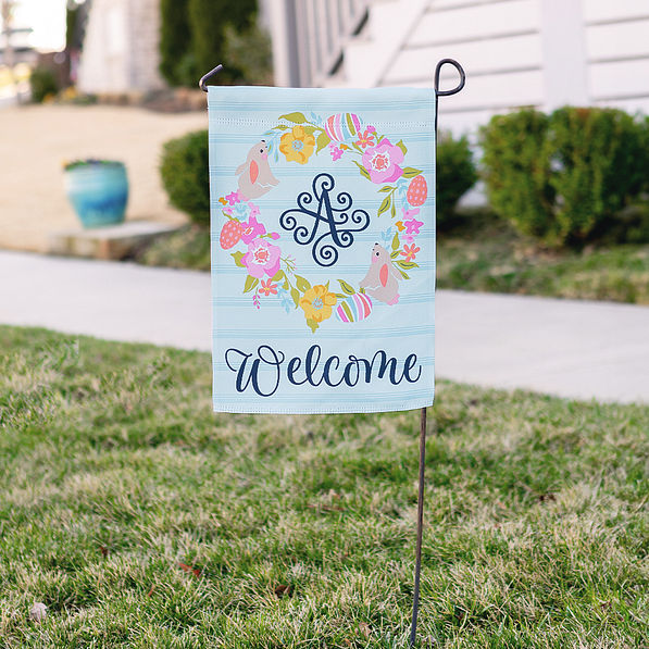 easter monogrammed garden flag next to sidewalk