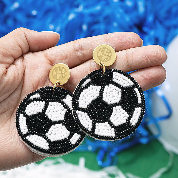 monogrammed soccer earrings in hand