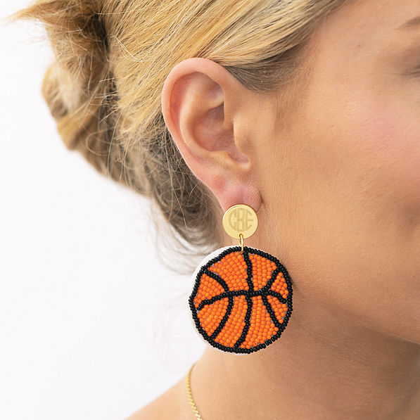 girl wearing monogrammed basketball earrings in ear