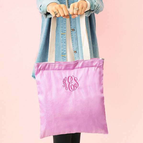 girl with monogrammed shimmer tote bag in pink in hands