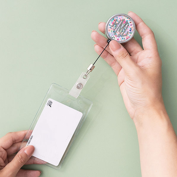 girl holding monogrammed coral floral badge reel