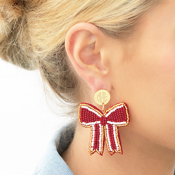 crimson gameday bow earrings in ear