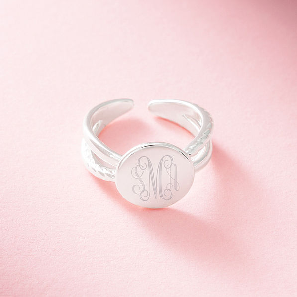 silver criss cross ring on pink background
