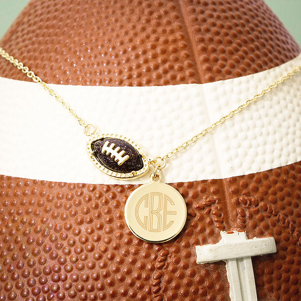 brown football necklace on football