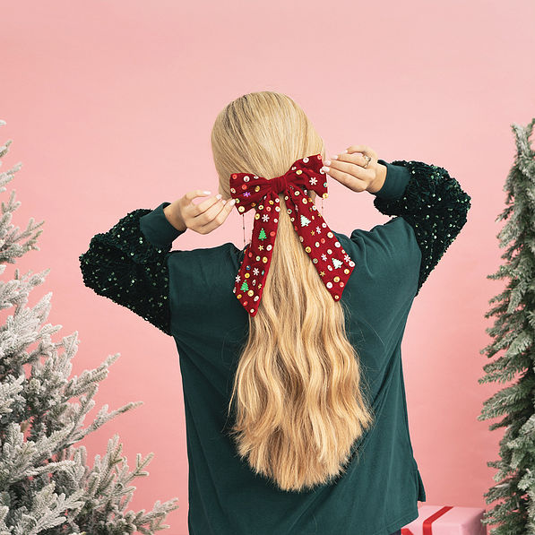 girl touching christmas velvet bow back
