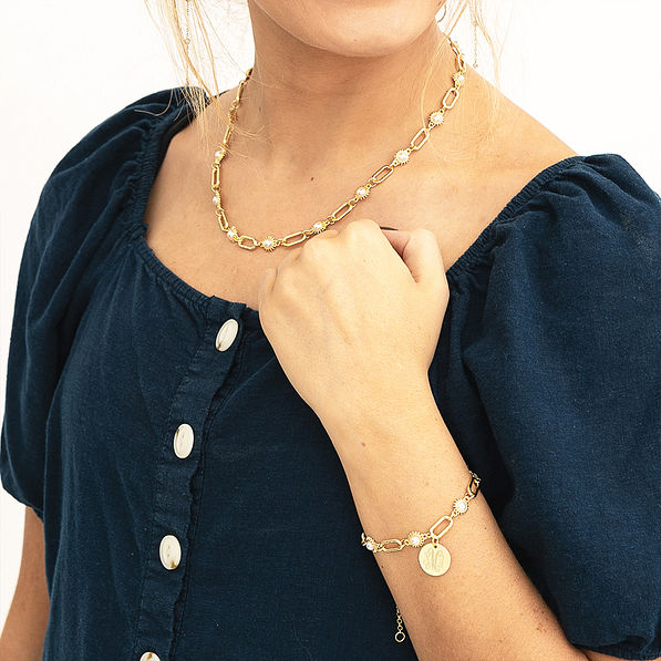 gold pearl starburst necklace with bracelet on arm