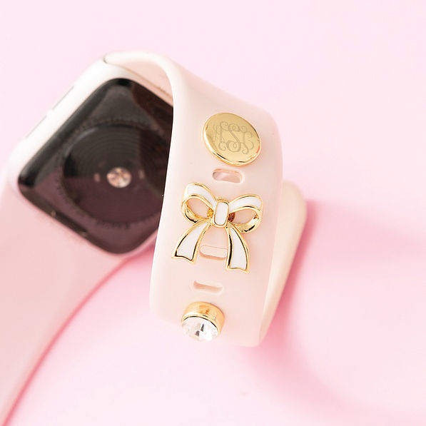 up close of monogrammed bow smartwatch charm set in gold on watch