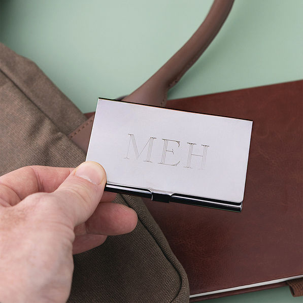 man holding stainless steel business card closed
