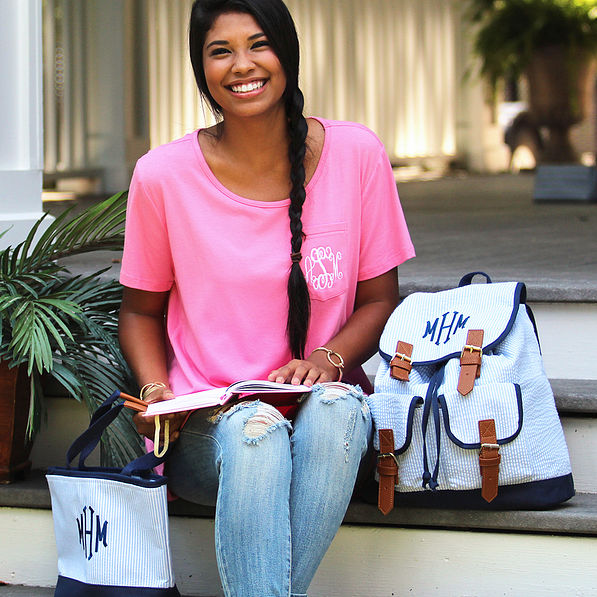 Girl sitting on steps with monogrammed blue seersucker bookbag and lunch bag