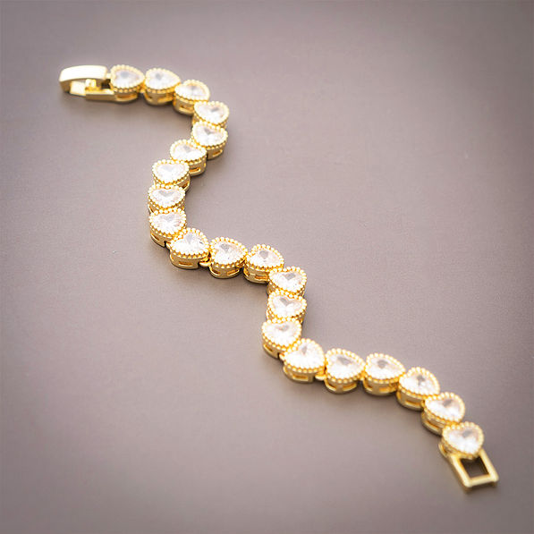 gold rhinestone heart bracelet on brown background