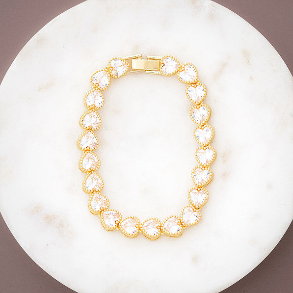 gold rhinestone heart bracelet on marble dish