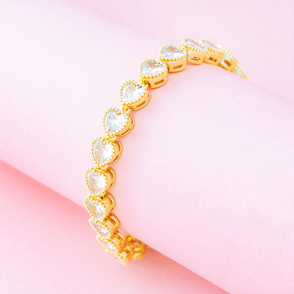 gold rhinestone heart bracelet on pink background