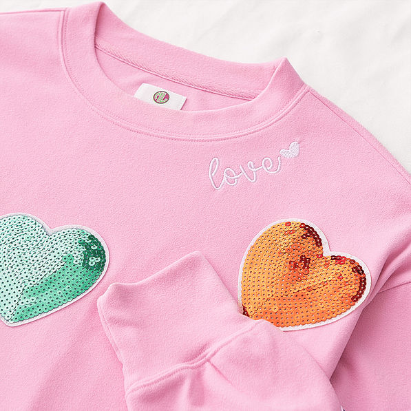 close up of pink sequin hearts sweatshirt