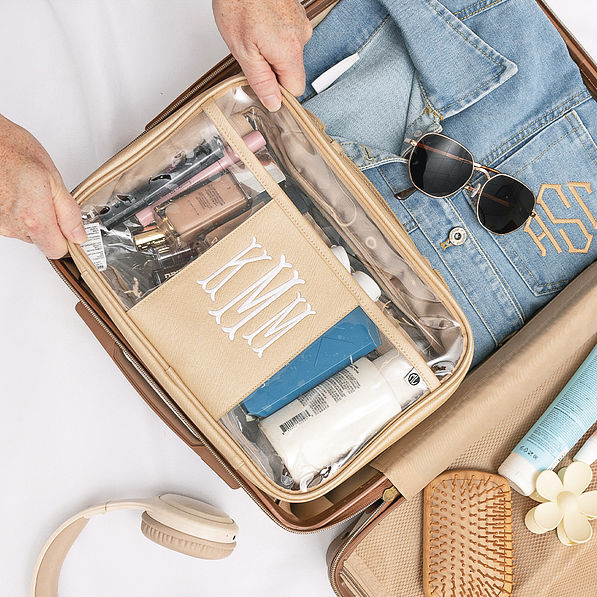 personalized large clear toiletry case in gold in luggage packed