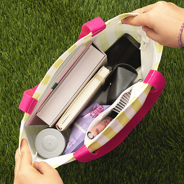 yellow and pink striped tote open on grass